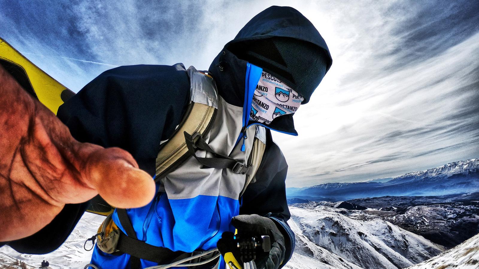 Vermummter Mann macht Selfie mit einer GoPro auf einem schneebedeckten Berg
