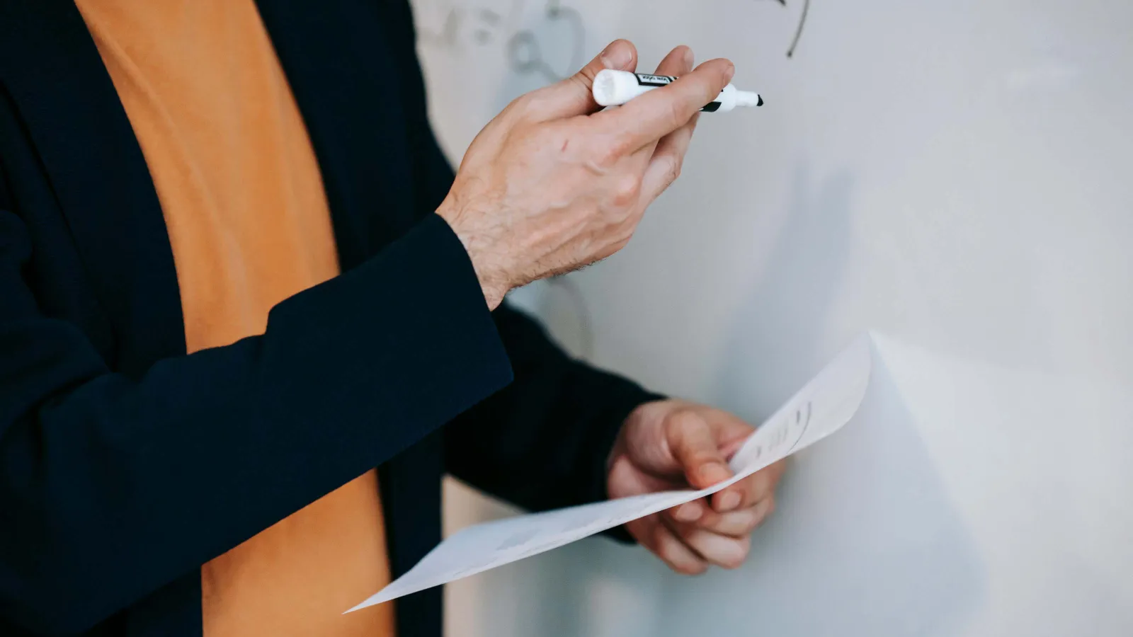 Eine Professorin schreibt etwas an ein Whiteboard 