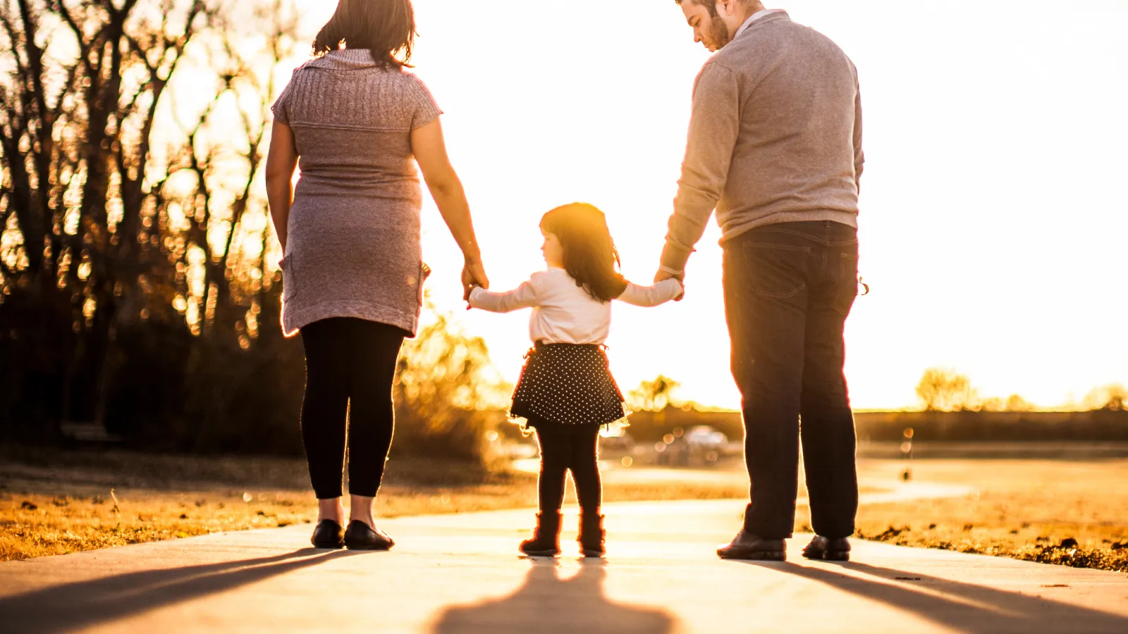 Familie geht mit einem Kind an der Hand spazieren