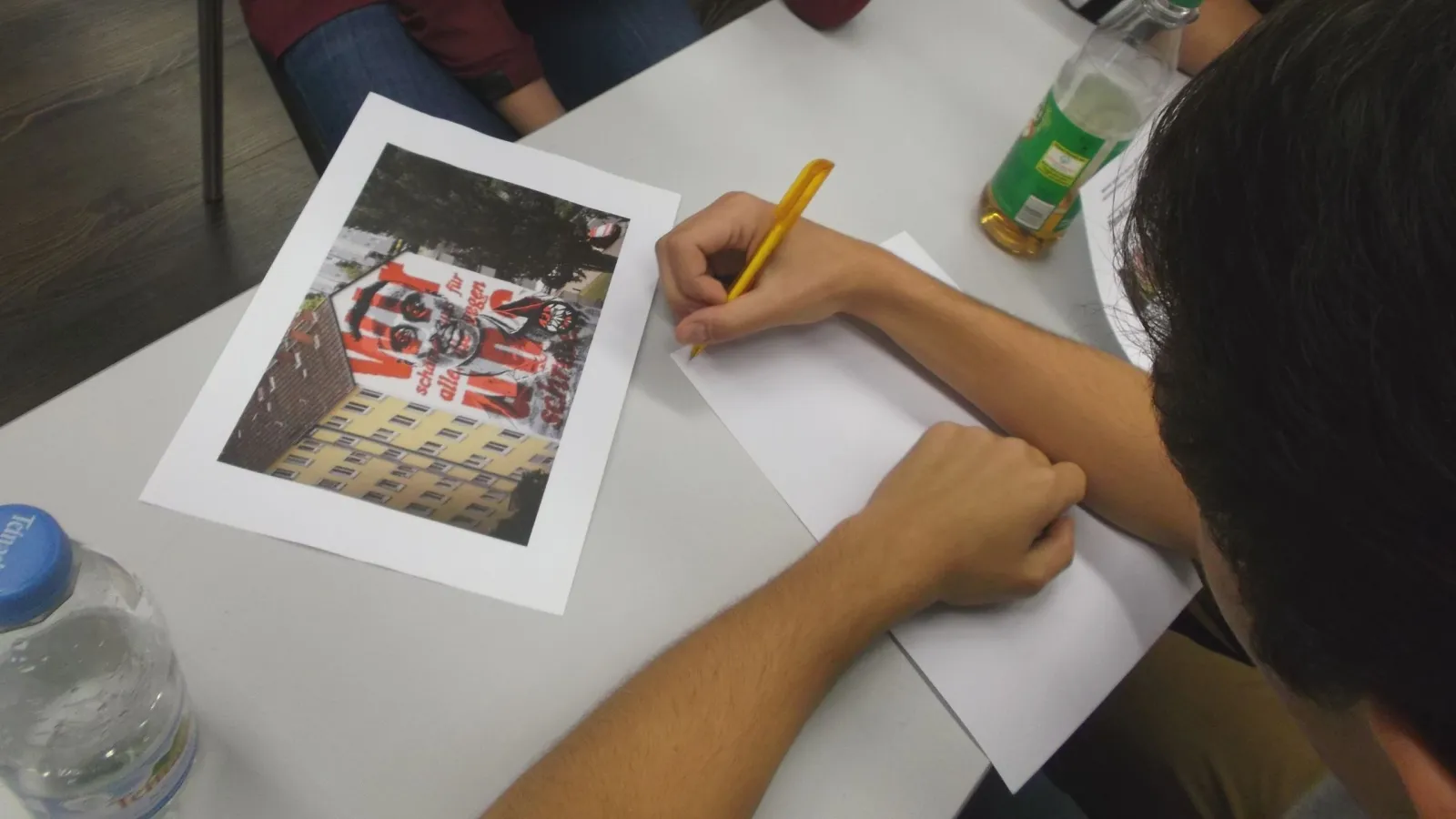 Foto einer Person, die auf einem Zettel schreibt