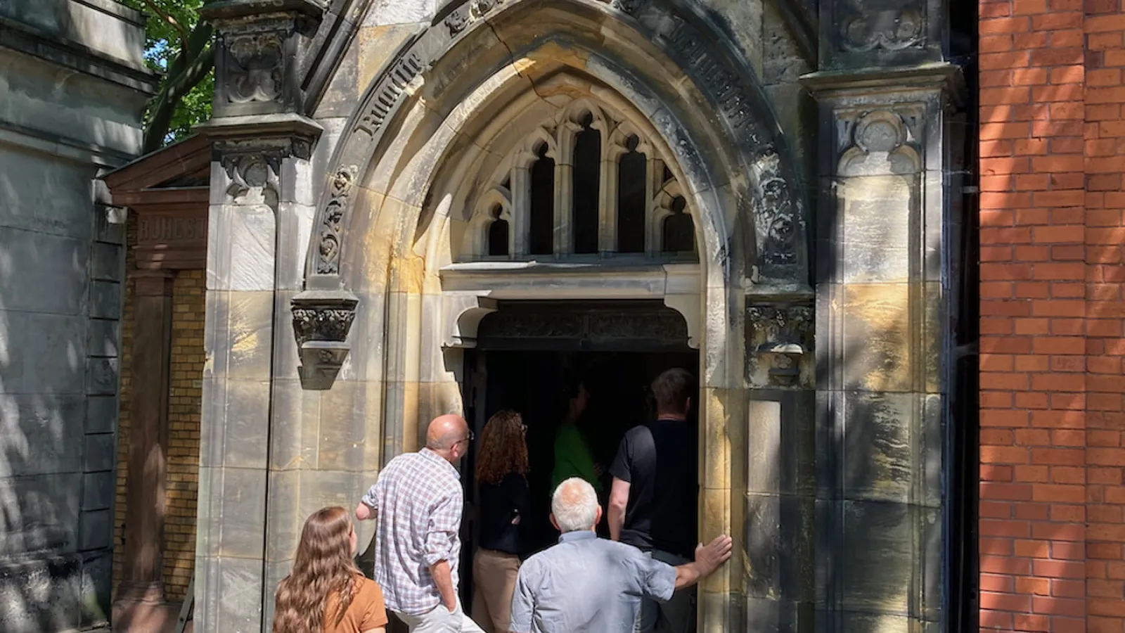 Beteiligte der Denkmalbehörden, der Stiftung und der Gemeinde gehen in das Mausoleum Neumeister.