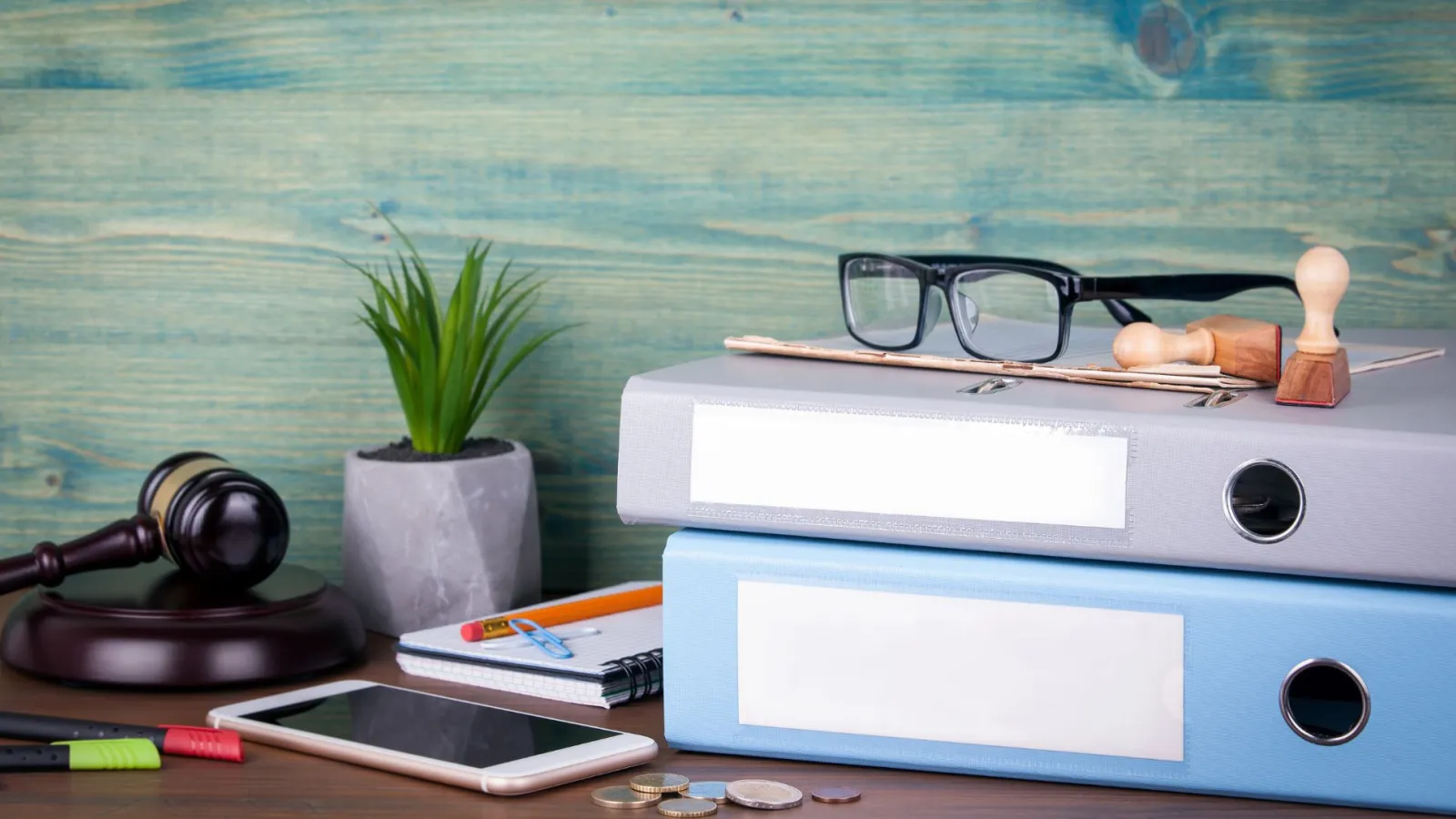 Aktenordner auf Tisch mit Brille und Bürozubehör