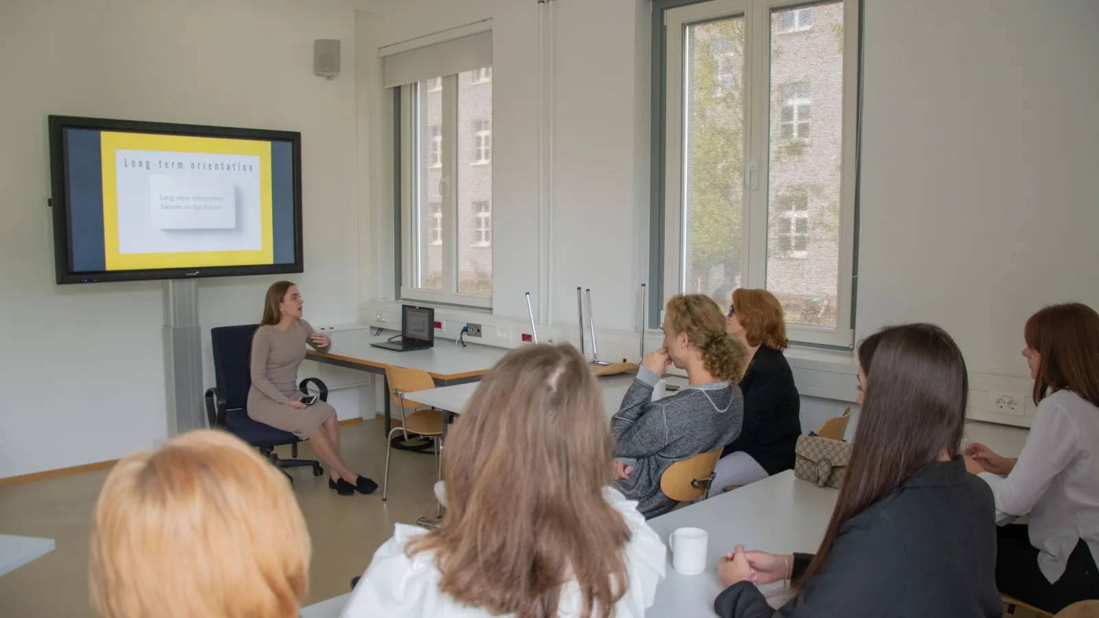 Lehrende und Teilnehmende der Summer School besprechen Präsentationen im Seminarraum.