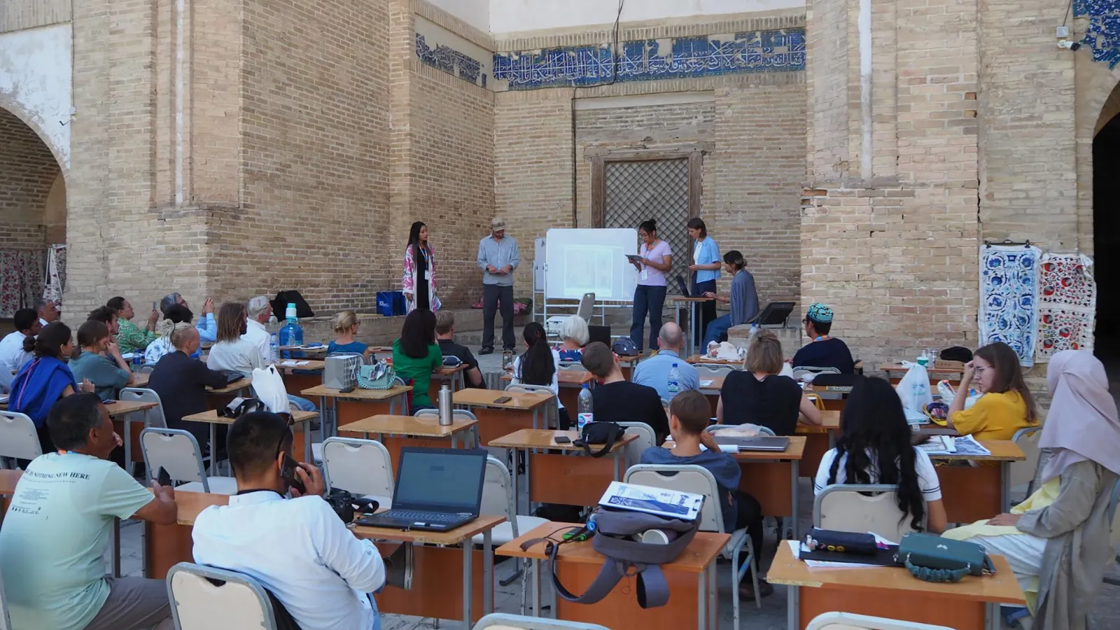 Studierende bei der Abschlusspräsentation der Summer School in der Kukeldash Medrese Buchara