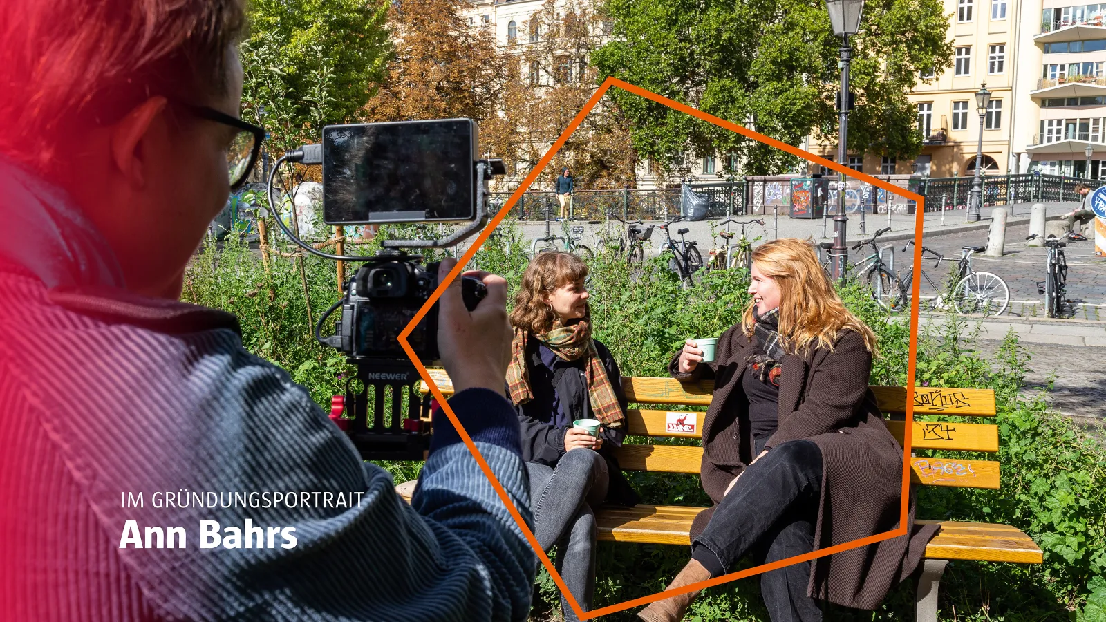 zwei Frauen sitzen auf einer Parkbank und werden gefilmt