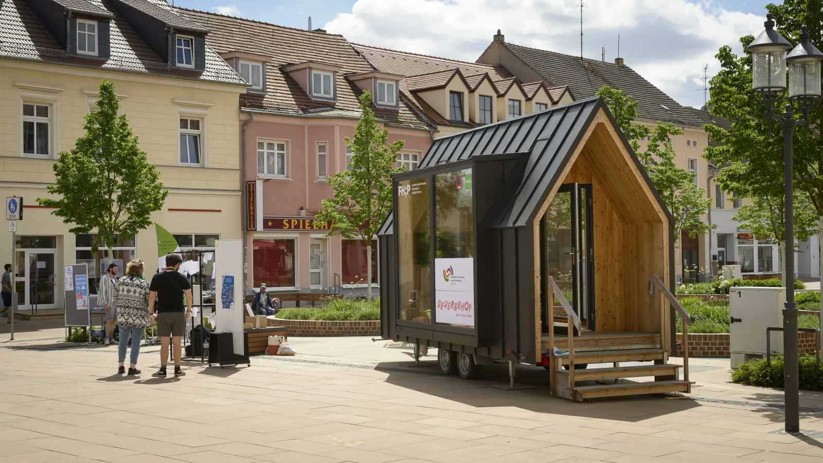 Das FHP Mobil steht auf dem Boulevard Luckenwalde, davor befinden sich zwei interessierte Besucher*innen