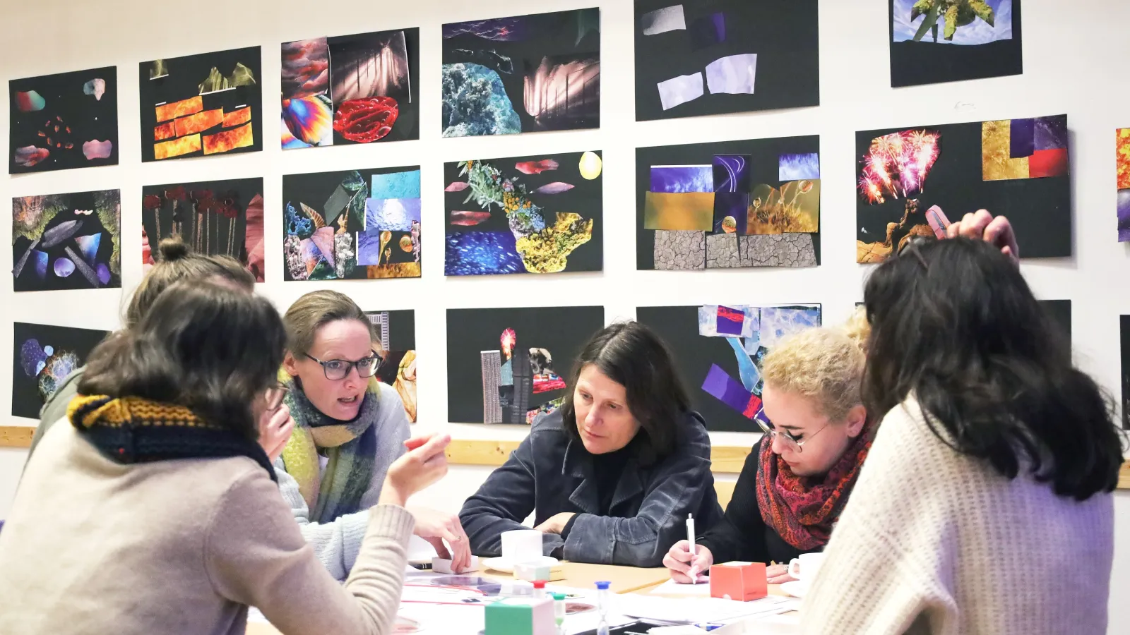 Fünf Frauen diskutieren über einen Projektentwurf.