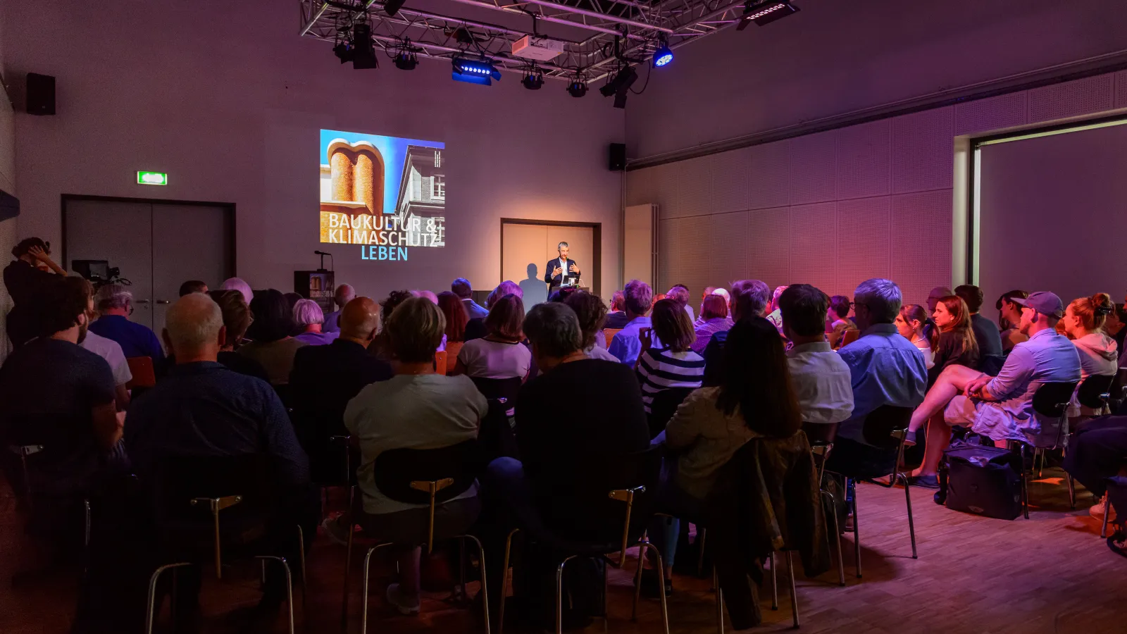 Prof. em. Dr. Vittorio Magnago Lampugnani hält seinen Vortrag zum Thema "Die historische Stadt ist absolut modern. Fünf Begründungen." vor vielen interessierten Besucher*innen der 3. Veranstaltung der Reihe Baukultur und Klimaschutz leben