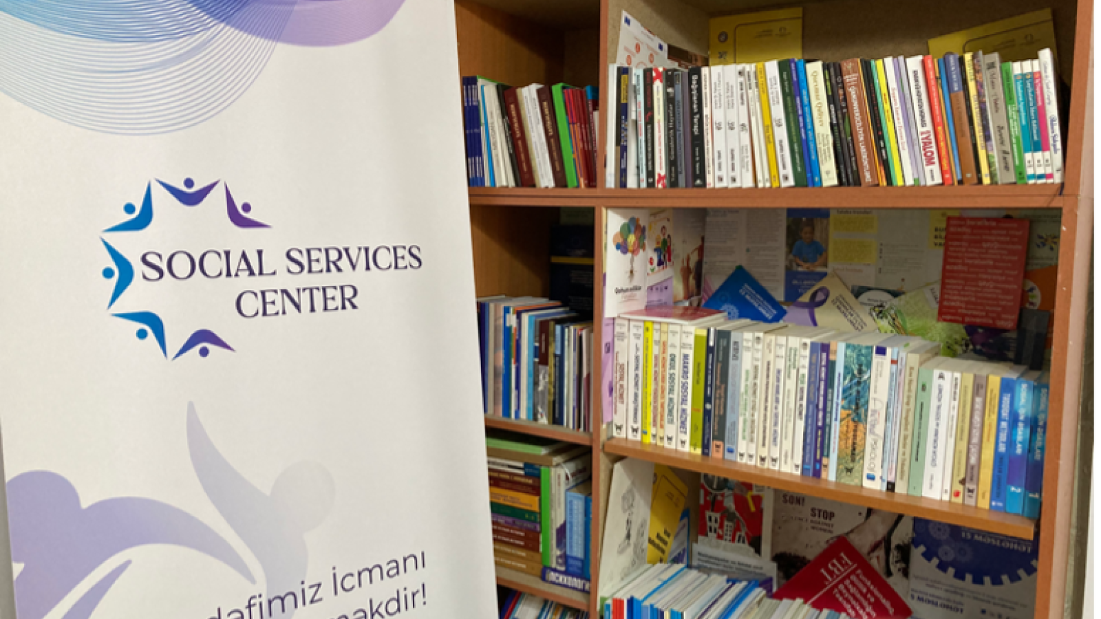 Ein Foto der Bibliothek des Gender Resource Center in Baku mit einem Plakat und einem Bücherregal