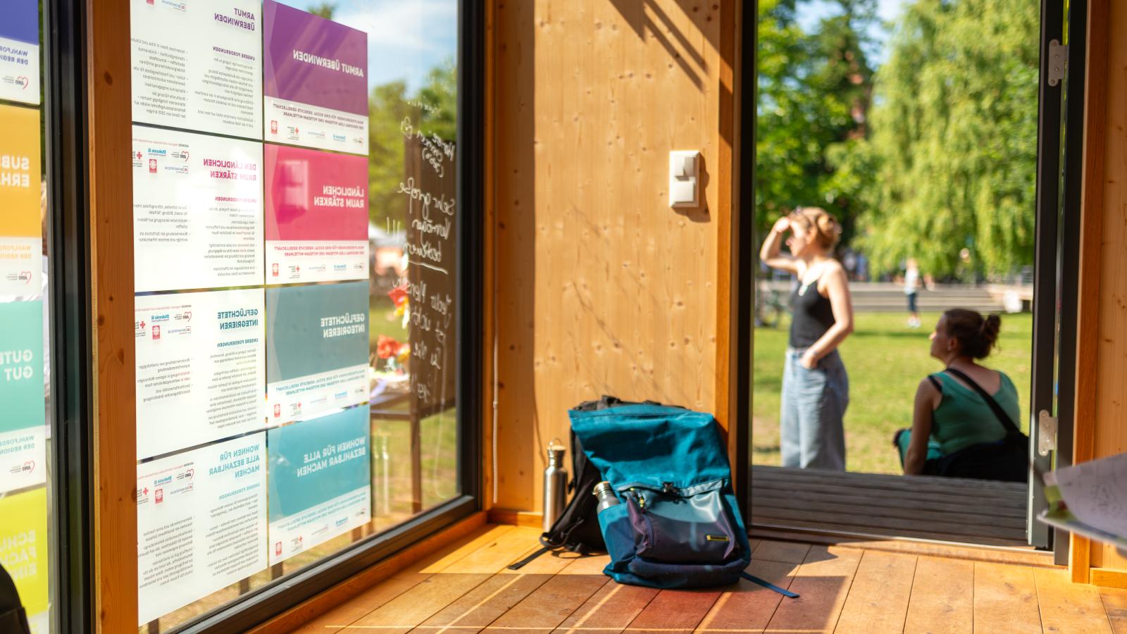An der Scheibe des FHP Mobils sind Plakate mit Wahlforderungen der Brandenburger Sozialverbände befestigt, der Blick richtet sich auf den Weidenpark in Eberswalde