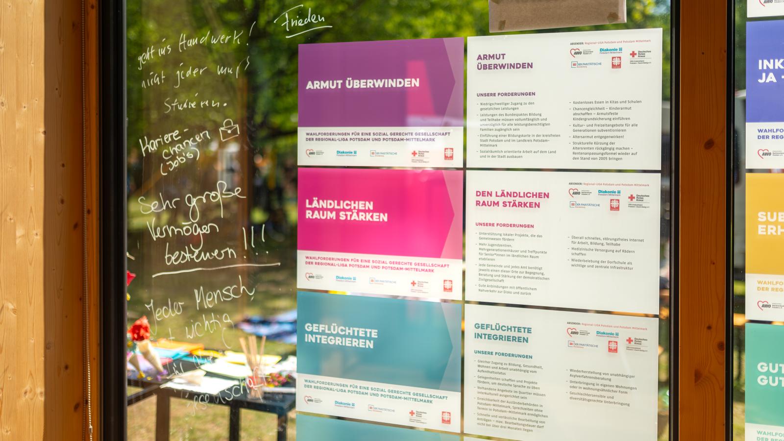 An der Scheibe des FHP Mobils sind Plakate mit Wahlforderungen der Brandenburger Sozialverbände zu sehen