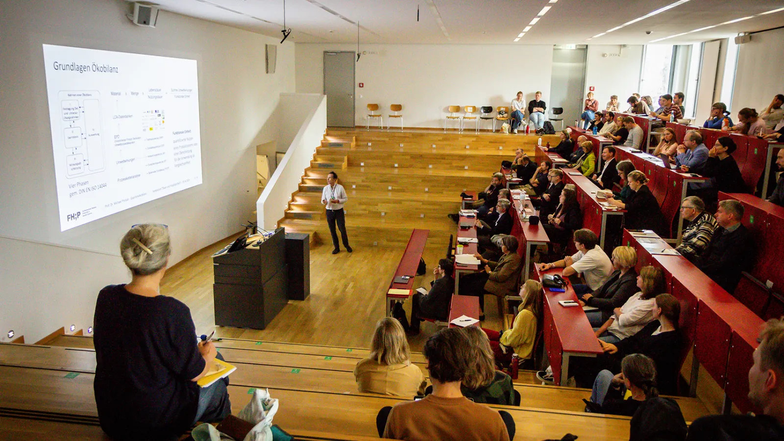 Eindruck des Hörsaals während des ibb Symposiums mit Zuschauenden.