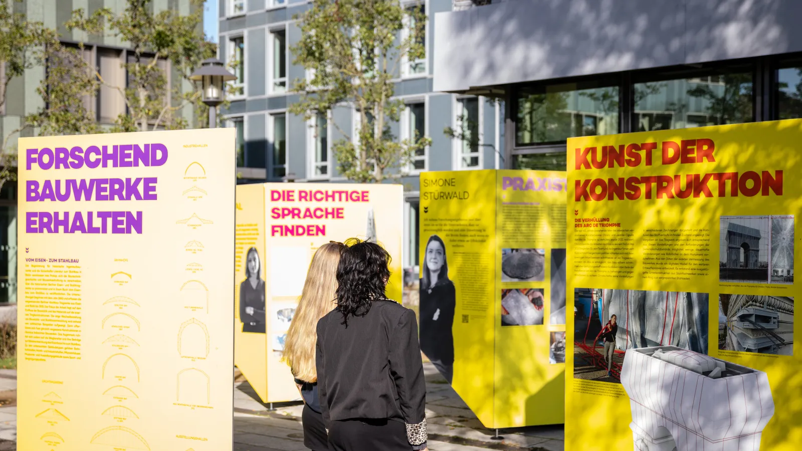 Personen betrachten die Ausstellung auf dem Campus-Außengelände