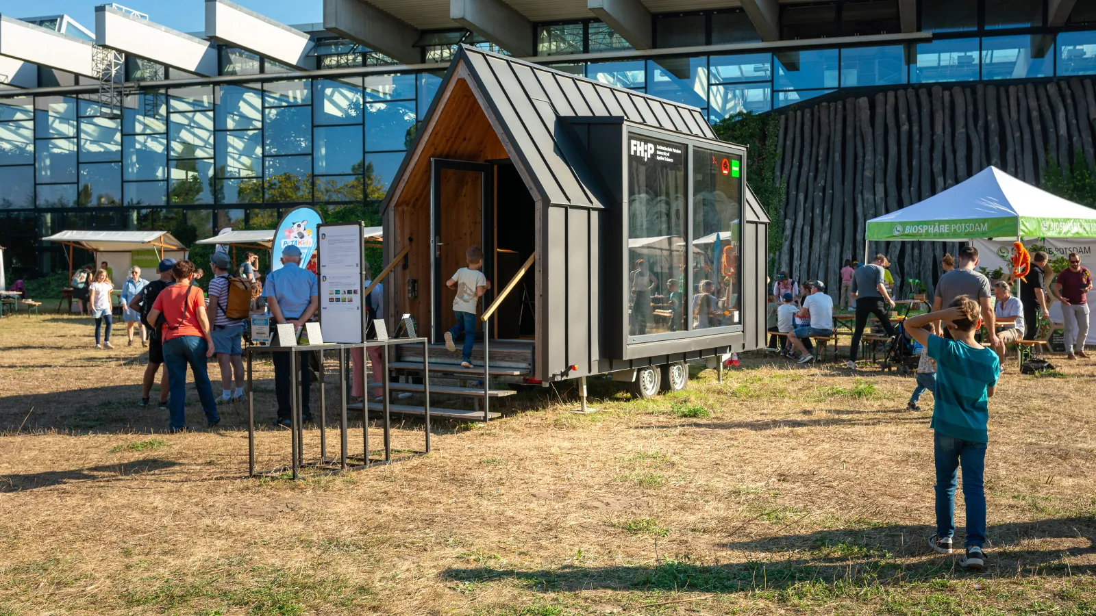 Ein Foto des FHP Mobils auf der großen Wiese im Volkspark Potsdam vor der Biosphäre