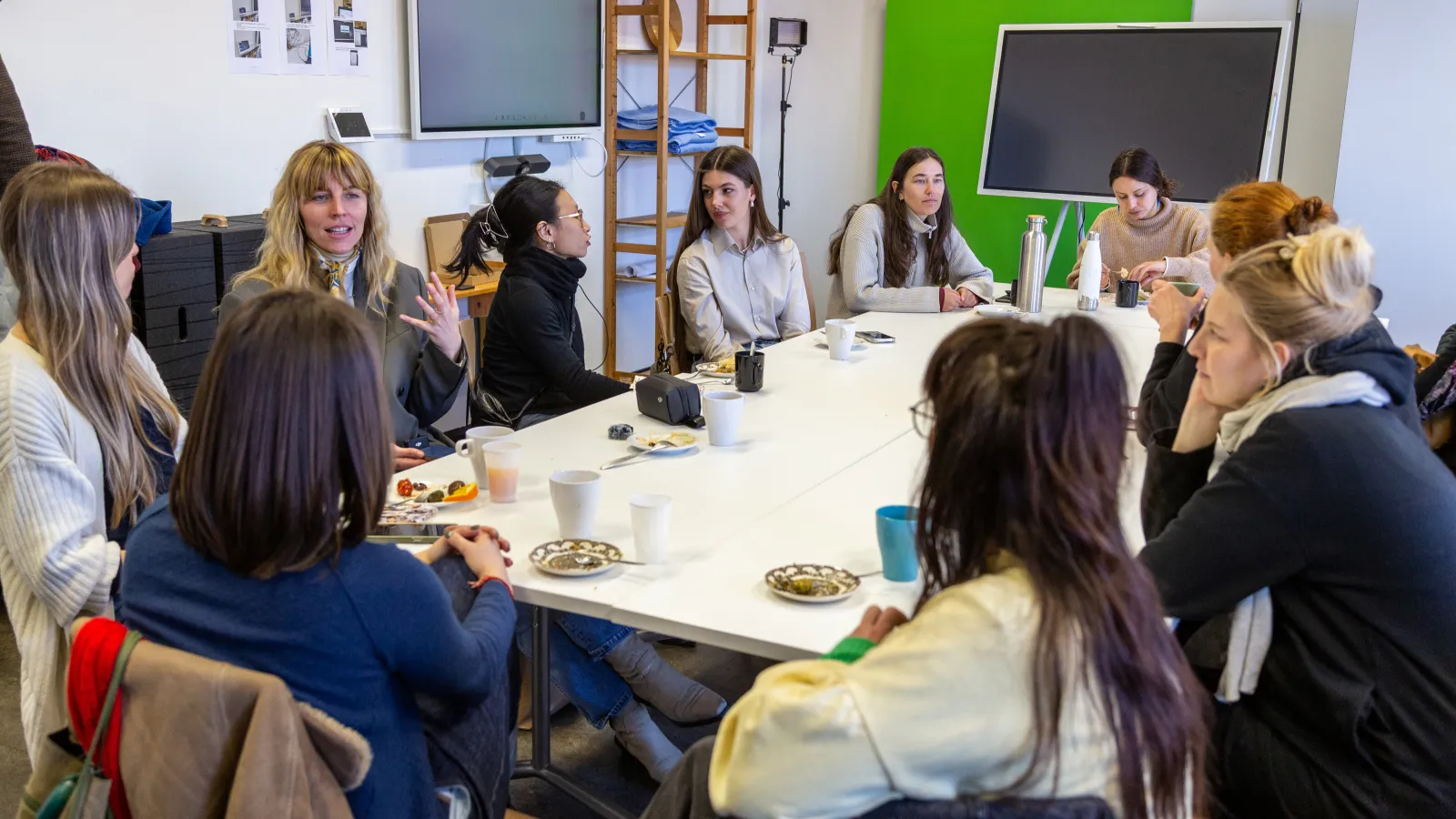 Gruppe von Frauen sitzt am Tisch und unterhält sich angeregt