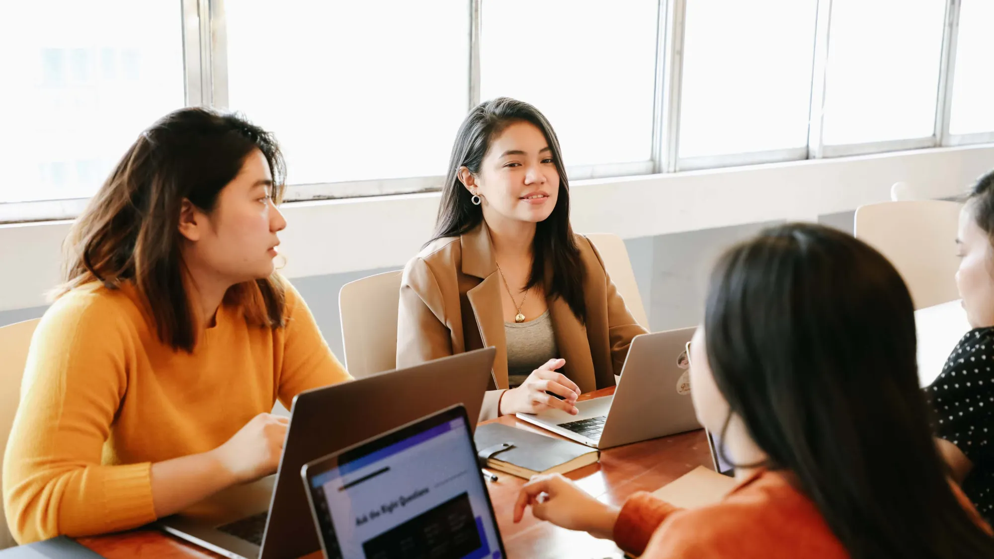 Internationale Studierende arbeiten gemeinsam an einem Laptop