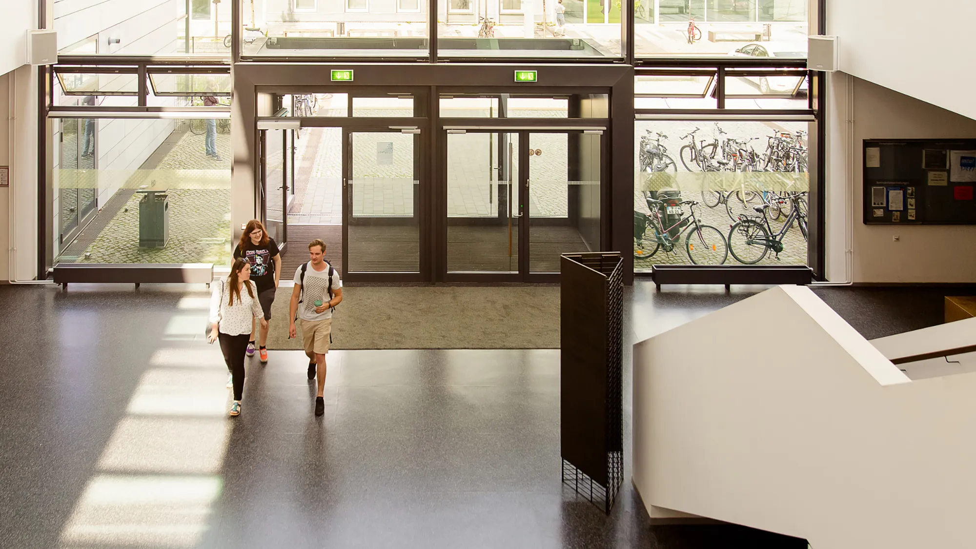 Drei Studierende im Foyer des Hauptgebäudes