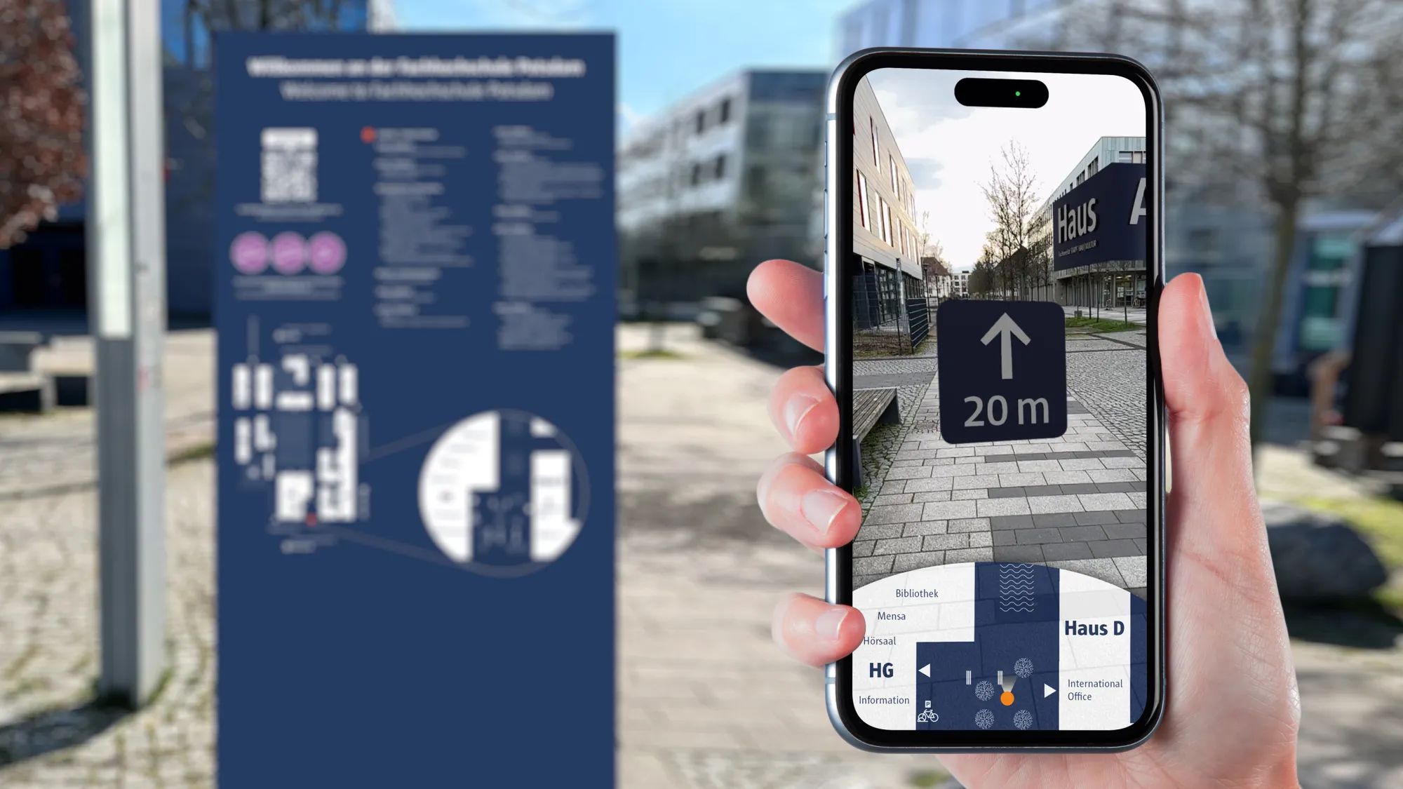 Hand mit Smartphone in der Hand vor unscharfem Hintergrund, auf dem eine Tafel mit Ortangaben auf dem Campus zu erkennen ist; Auf dem Smartphone ist eine AI-Anwendung mit Bild des Campus und Pfeil "20 m" zu erkennen