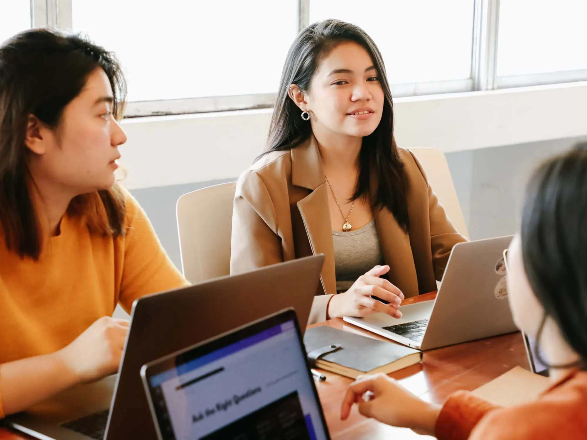 Internationale Studierende arbeiten gemeinsam an einem Laptop