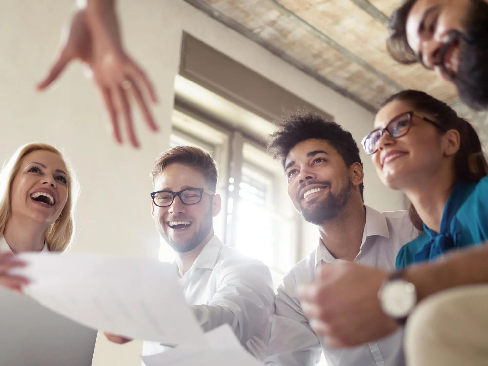 Studierende sitzen in einem Kreis in Arbeitsatmosphäre und lachen