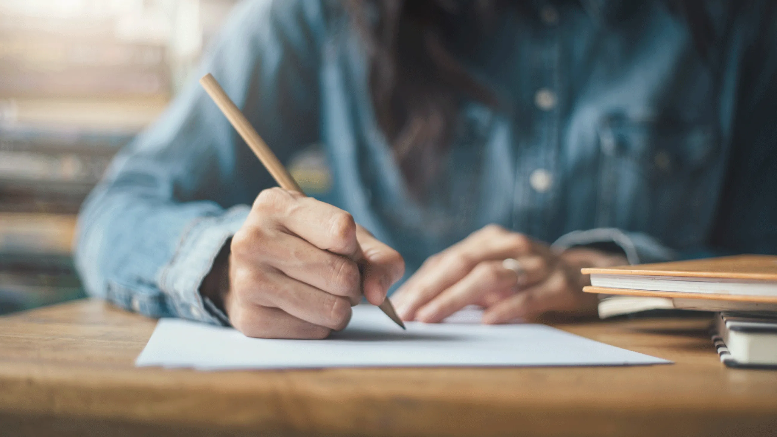 Zwei Hände schreiben mit einem Stift auf Papier