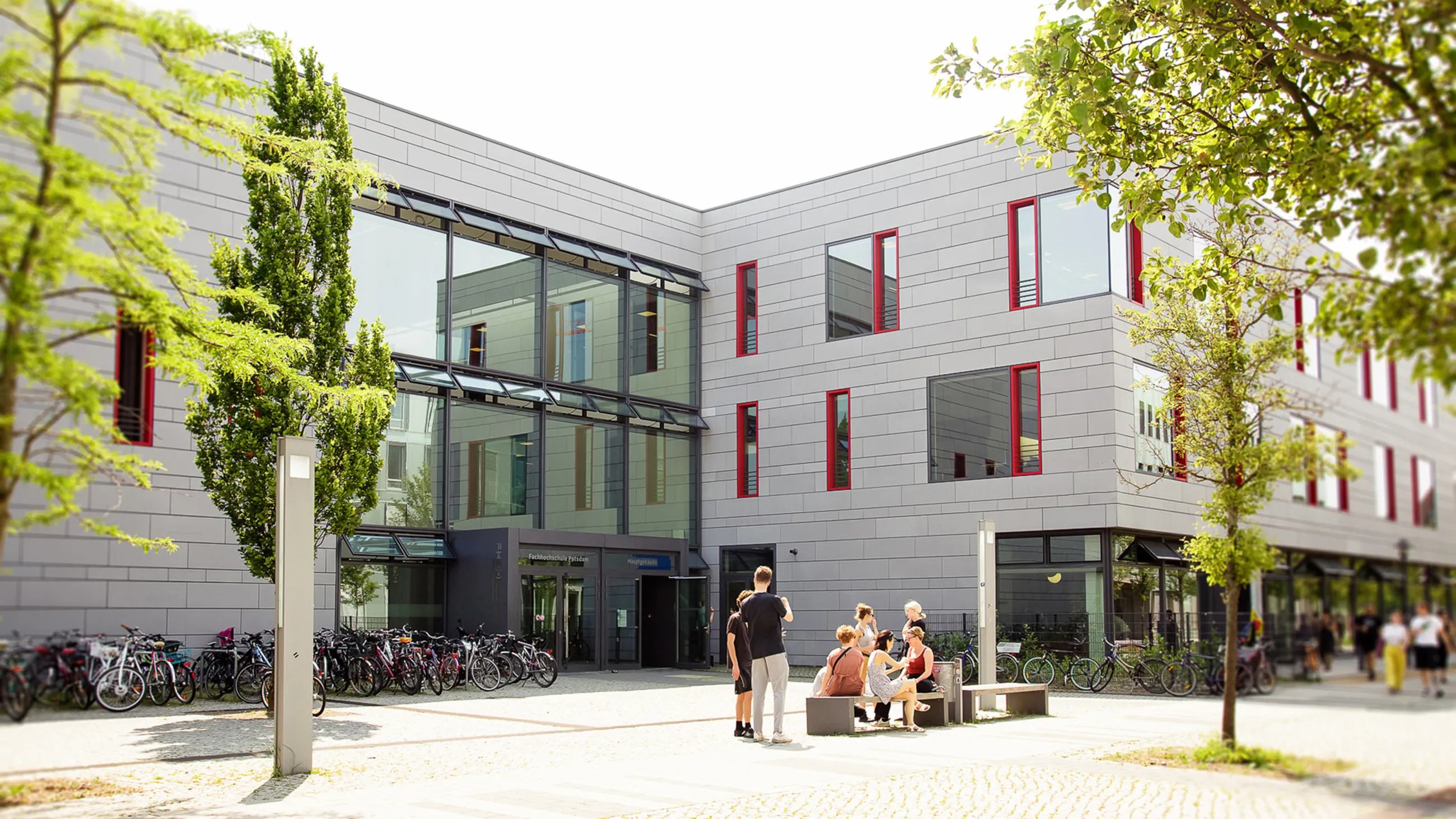 Studierende vor dem Hauptgebäude der FH Potsdam im Sommer