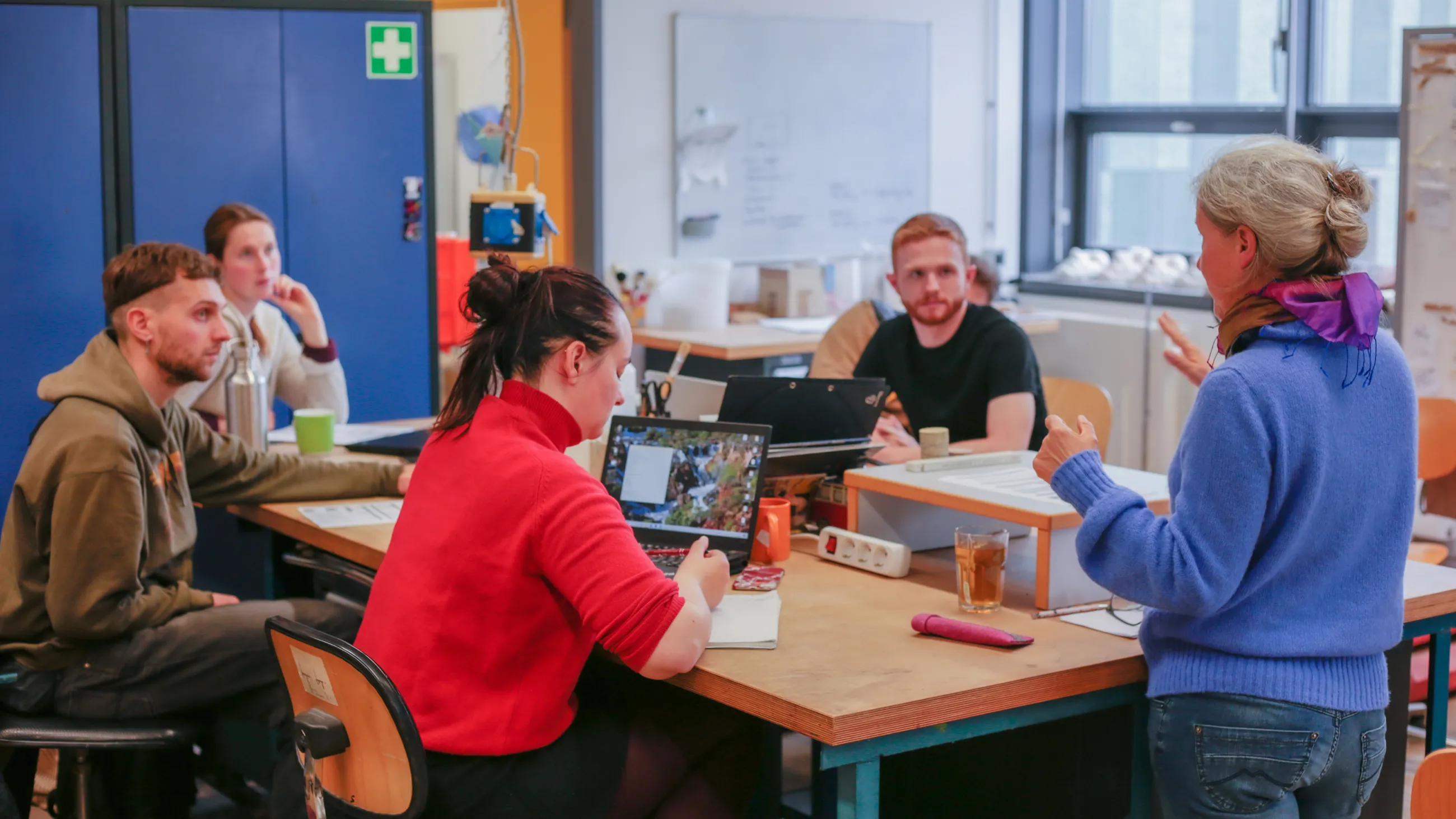 Studierende bei einer Besprechung an einem Tisch in der Stein-Werkstatt