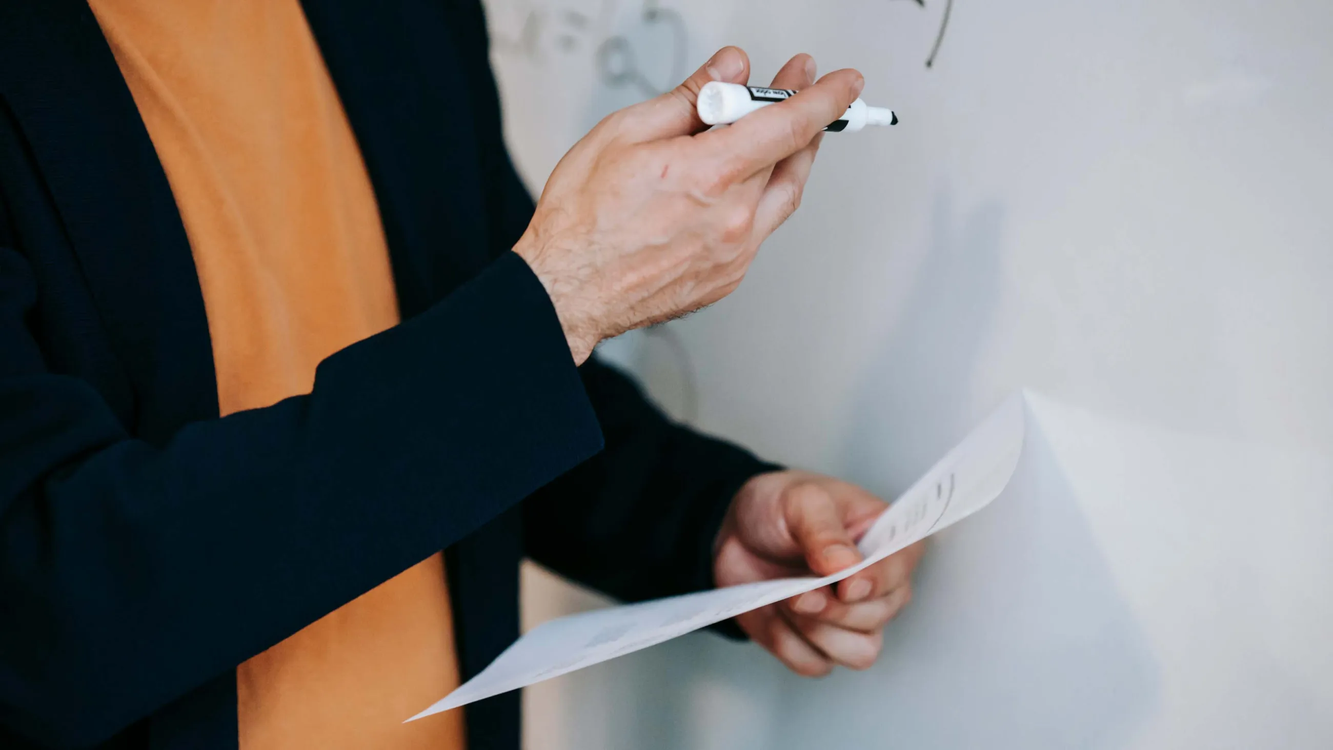 Eine Professorin schreibt etwas an ein Whiteboard 