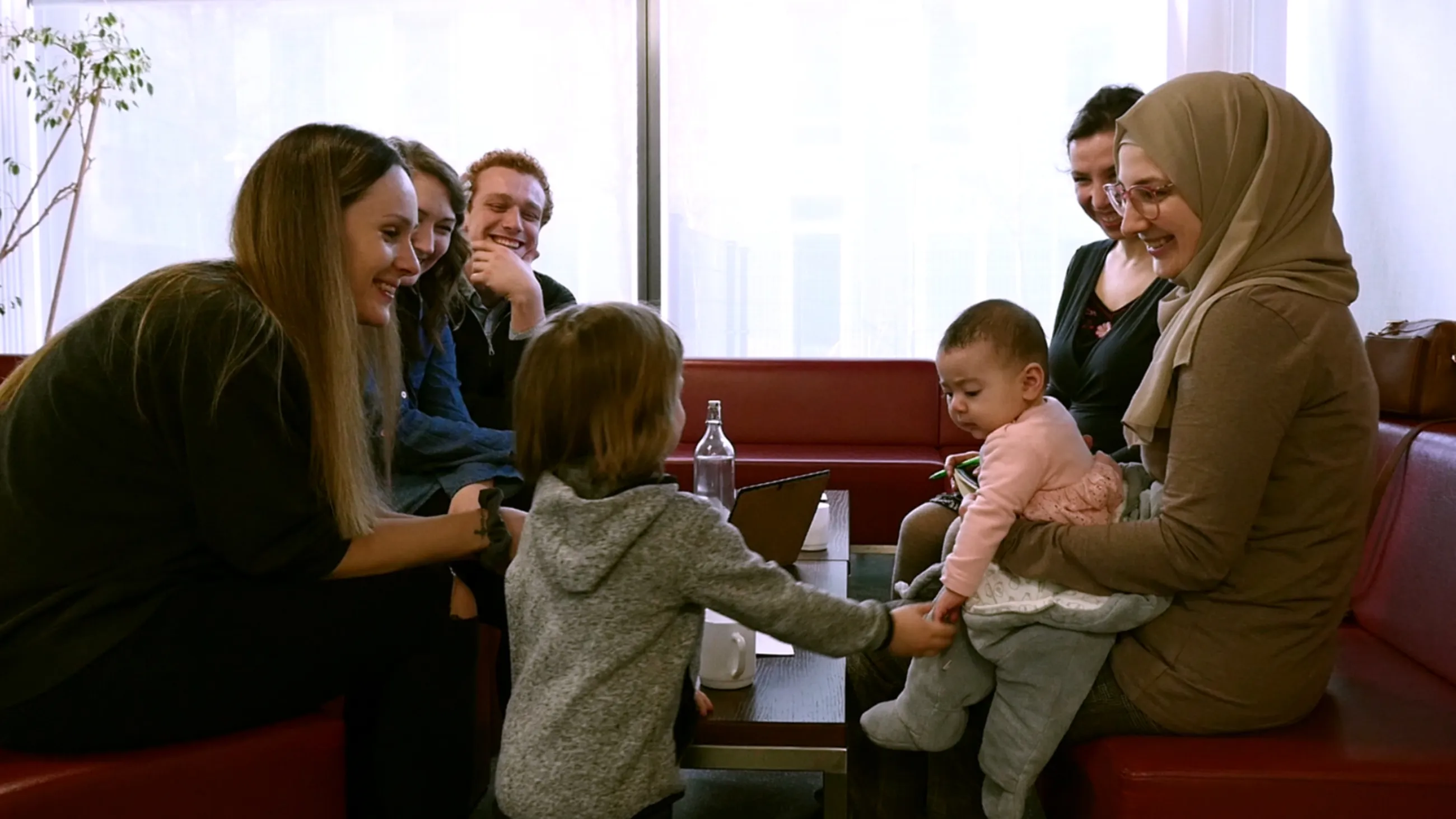 Studierende der FH Potsdam sitzen mit ihren Kindern zusammen und tauschen sich aus