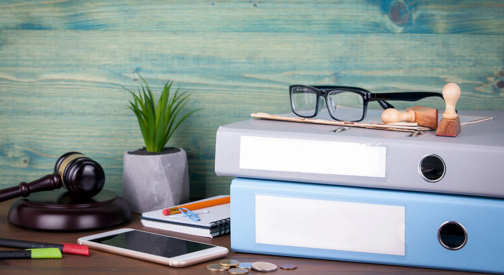 Aktenordner auf Tisch mit Brille und Bürozubehör