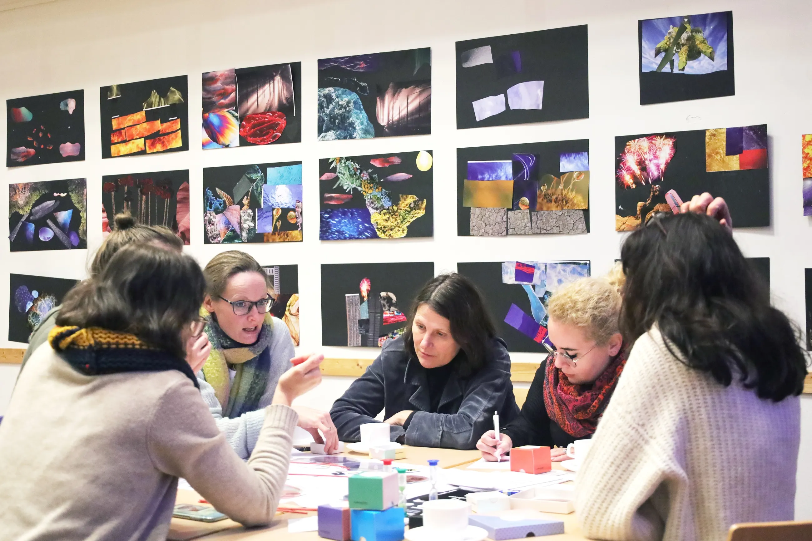 Fünf Frauen diskutieren über einen Projektentwurf.