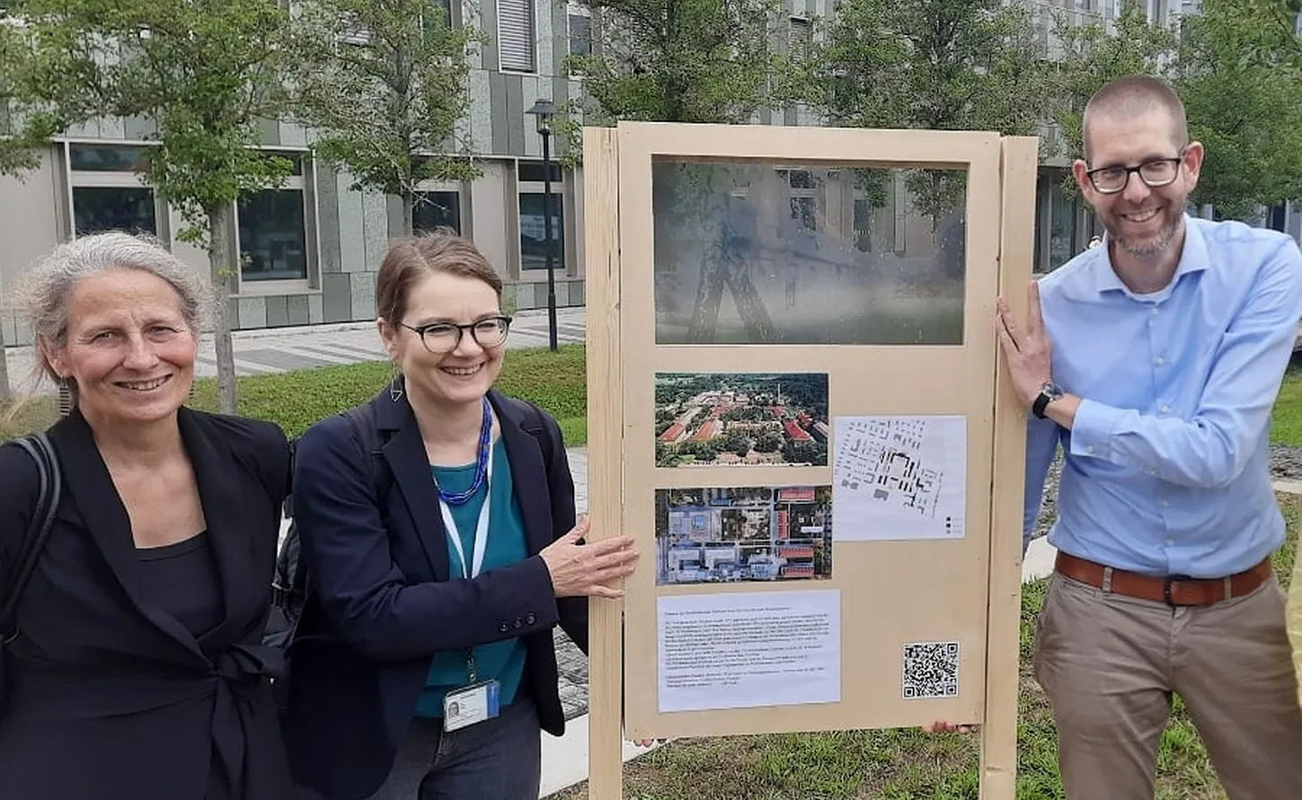 Prof. Dr. Eva Schmitt-Rodermund, Prof. Dr. Ulrike Wuttke und Prof. Dr. Rainer Schützeichel mit dem Prototyp des “Bornstedter Zeitfensters” auf dem FHP-Campus / Der Prototyp besteht aus einem Holzgetstell mit Campus-Bildern und Textpassagen