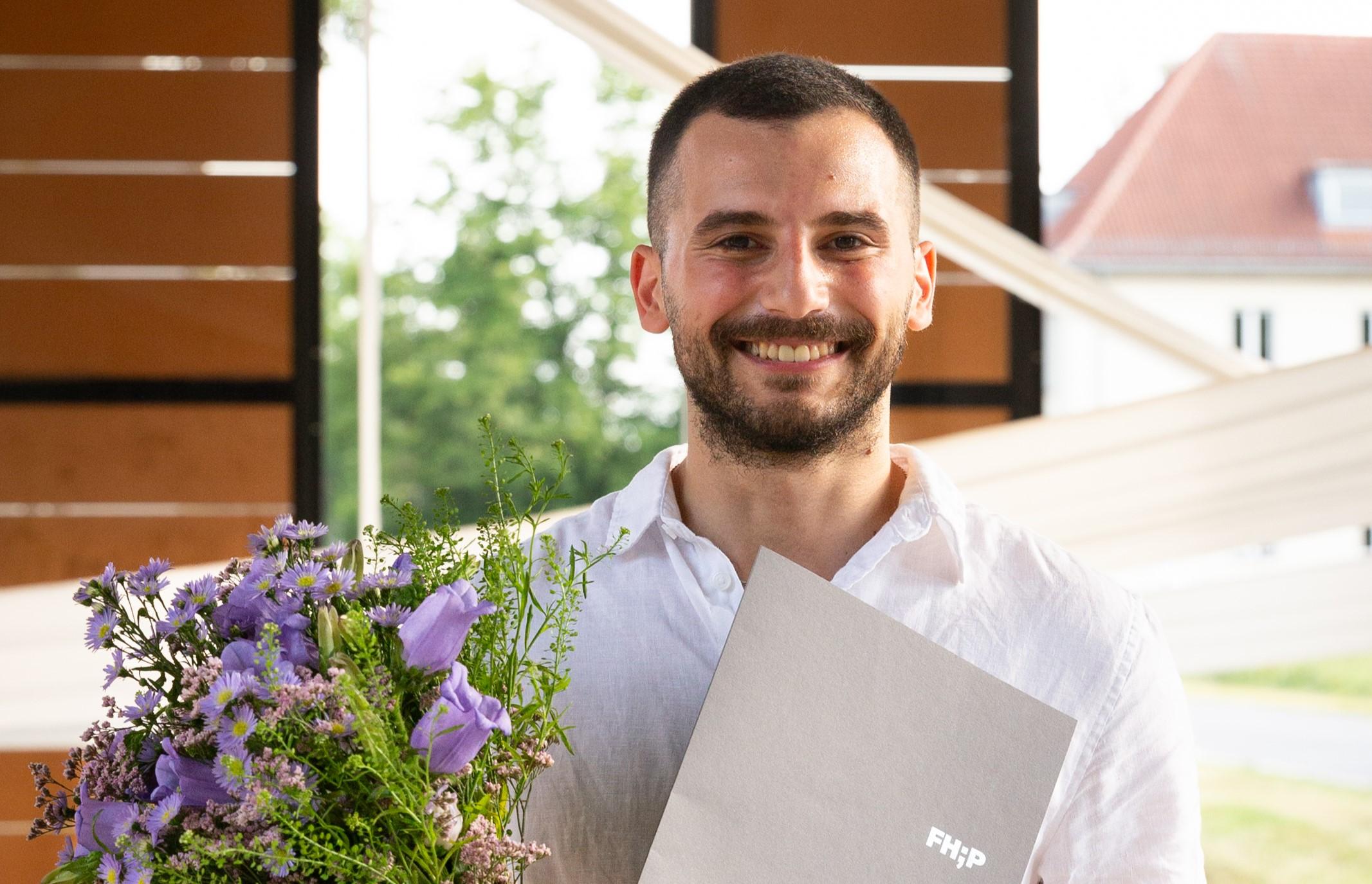 DAAD-Preisträger Hadi Daaboul mit Blumenstrauss und Urkunde
