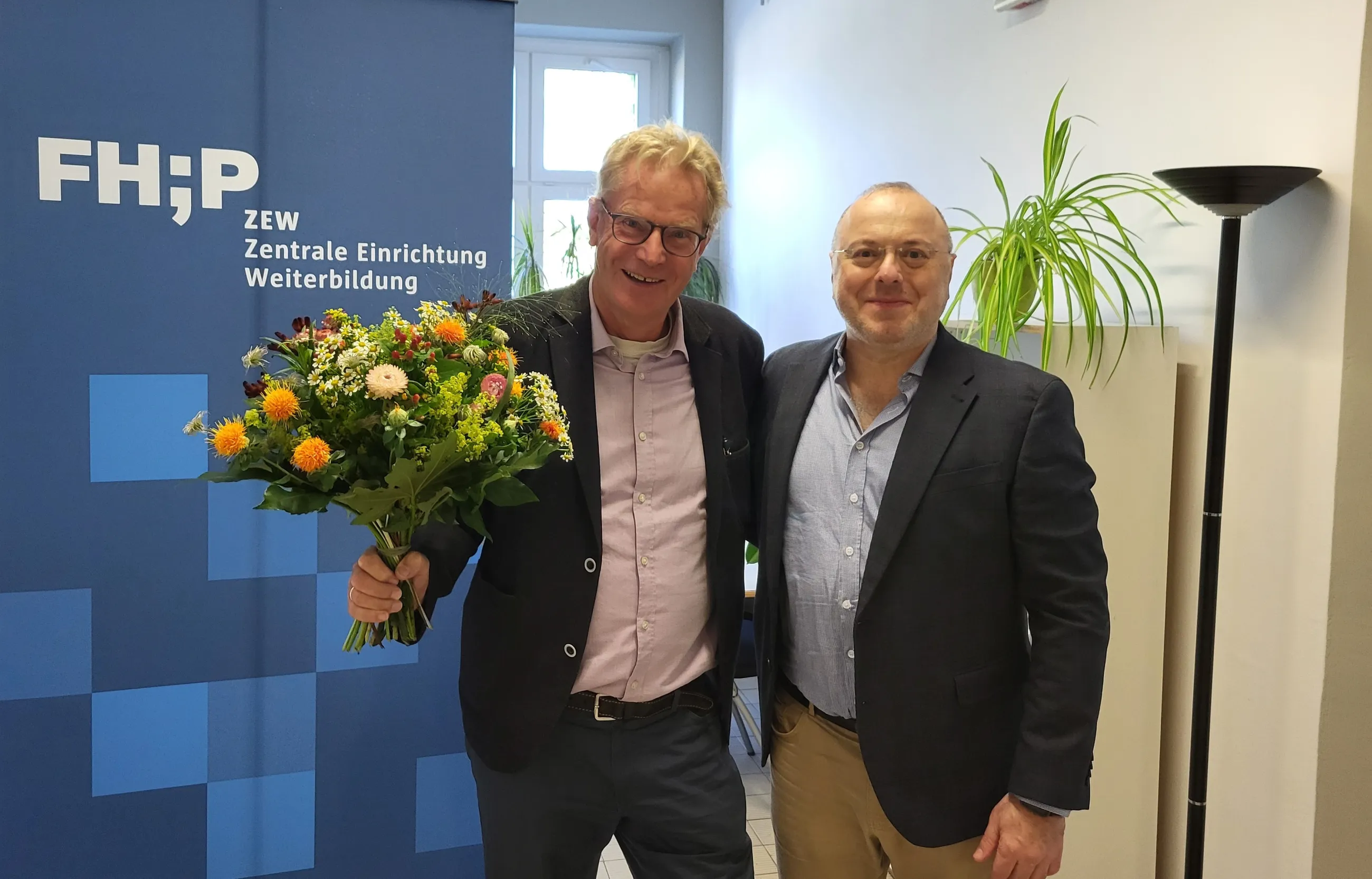 Prof. Knoesel mit Blumen und Mustafa Turna Frontalaufnahme