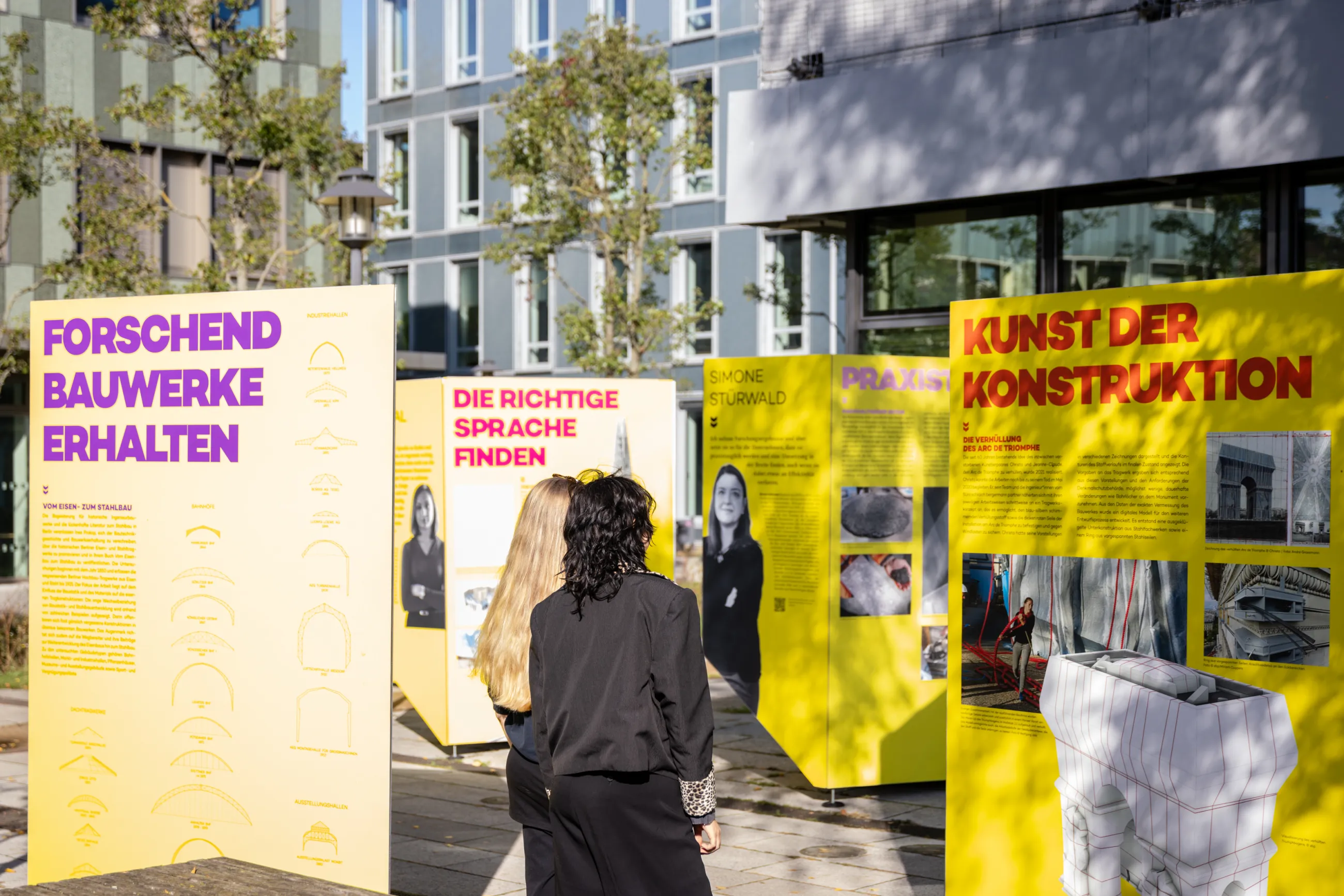 Personen betrachten die Ausstellung auf dem Campus-Außengelände