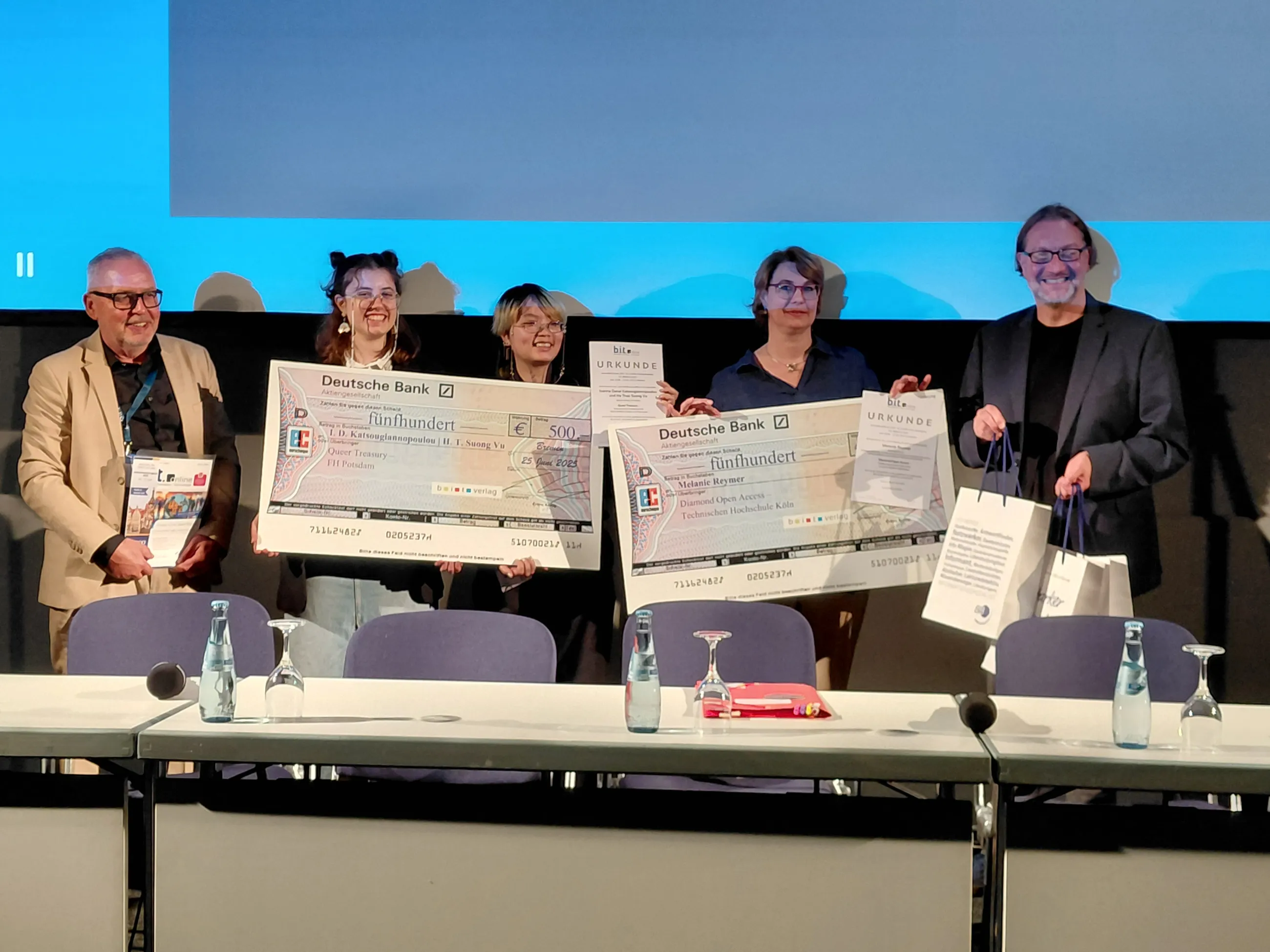 5 Personen mit Checks bei Preisverleihung b.i.t. online-Innovationspreis 2025