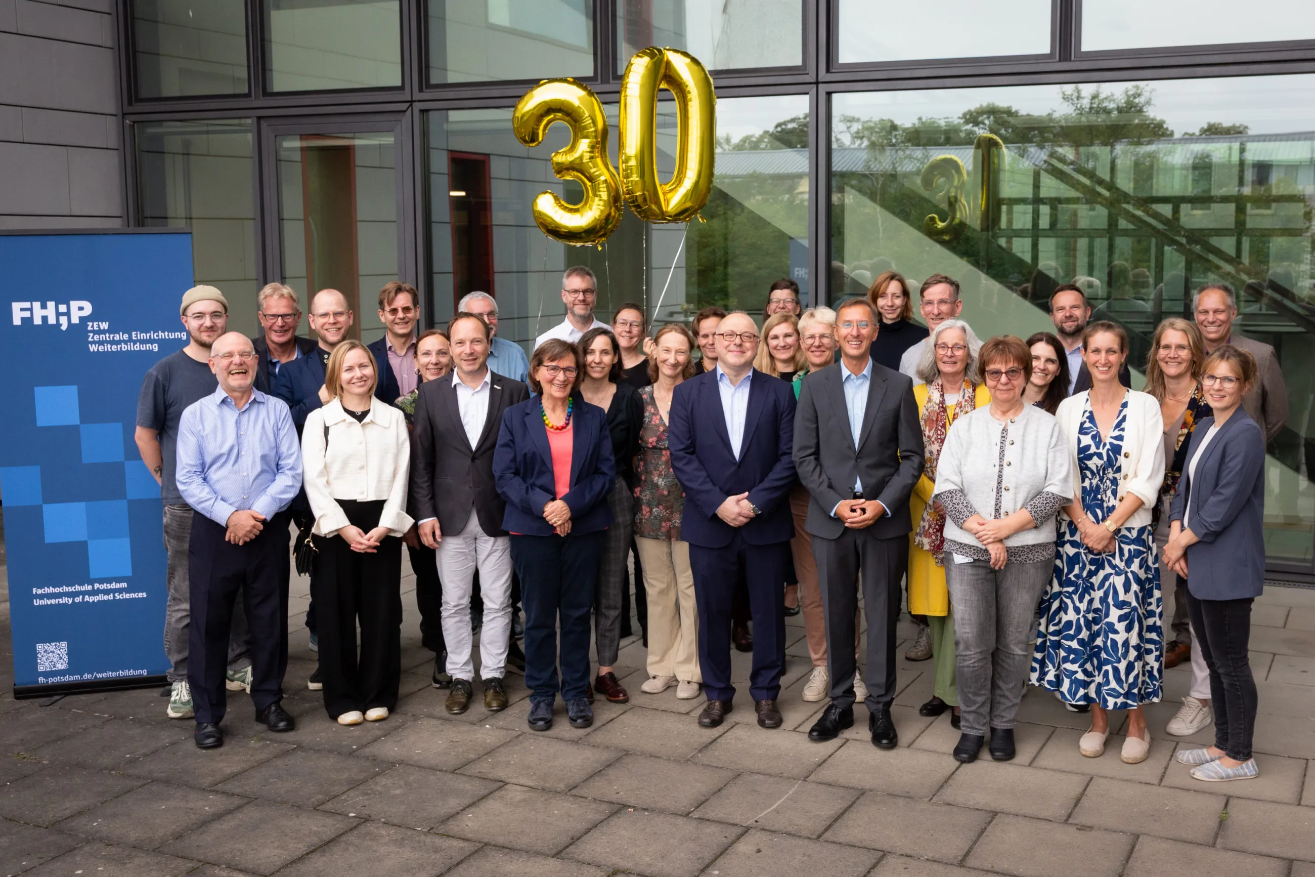 Gruppenbild der Gäste auf Terrasse mit 30 Ballon im Hintergrund